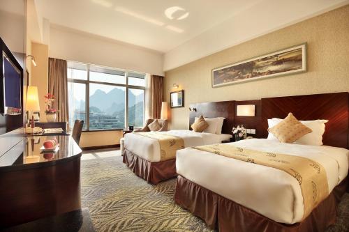 Postel nebo postele na pokoji v ubytování Lijiang Waterfall Hotel Guilin
