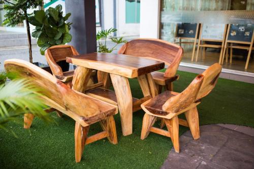 a wooden table and four chairs around a wooden table and chairs at Orkid Inn Mahkota Cheras in Kampong Perimbun