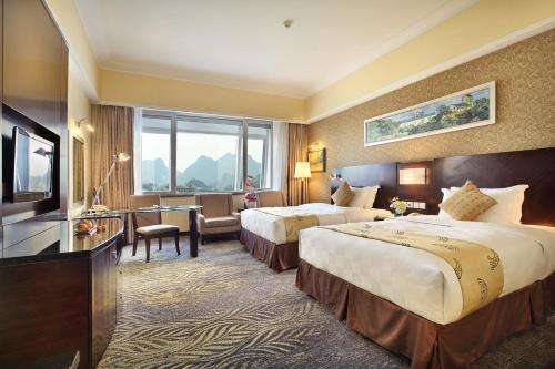 Postel nebo postele na pokoji v ubytování Lijiang Waterfall Hotel Guilin