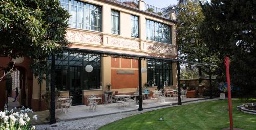 a building with tables and chairs in a yard at Villa Belverde Boutique Hotel in Carrara