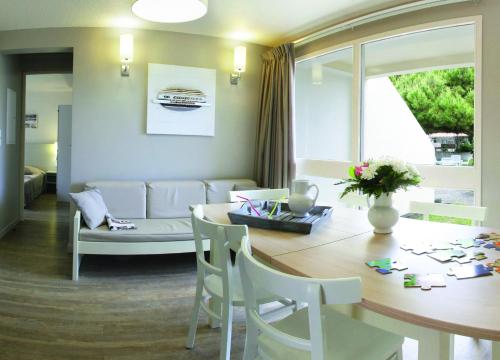un salon avec une table et un canapé dans l'établissement VVF Île de Ré Sainte-Marie-de-Ré, à Sainte-Marie de Ré