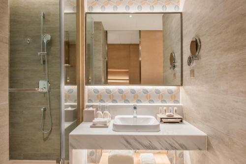 uma casa de banho com um lavatório e um chuveiro em Holiday Inn Resort Yichun Mingyue Mountain, an IHG Hotel em Yichun