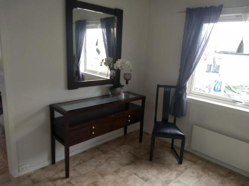 a dresser with a mirror and a chair in a room at 43 Oscarsgate in Vadsø