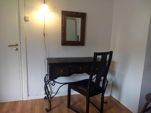 a black desk with a chair and a mirror at 43 Oscarsgate in Vadsø