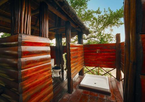 a porch of a wooden cabin with a toilet on it at Pezulu Tree House Lodge in Hoedspruit