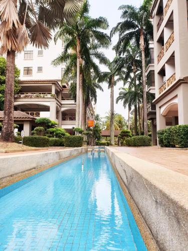 a swimming pool in front of a building with palm trees at Mahkota Seaview Condo Homestay Near A'Famosa jonker Melaka in Melaka