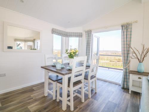 a dining room with a table and chairs and a window at Beech Lodge in Newton Abbot