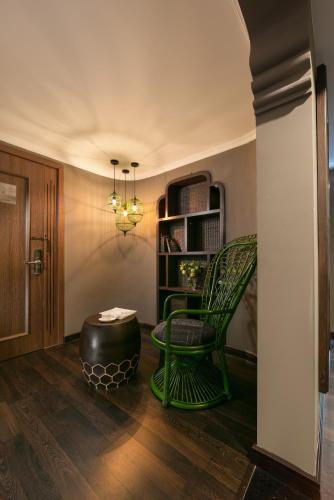 a room with a green chair and a ottoman at Pistachio Hotel Sapa in Sa Pa