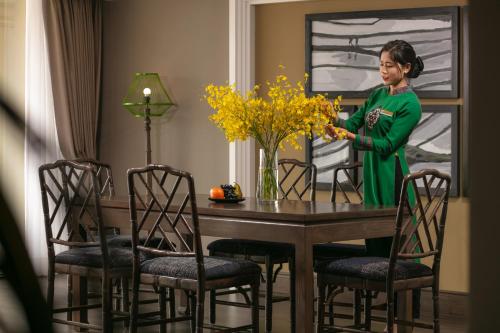 a woman standing at a table in a dining room at Pistachio Hotel Sapa in Sa Pa