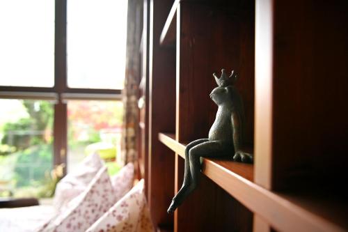 a statue of a frog sitting on a shelf next to a window at Villa Rana in Lindau