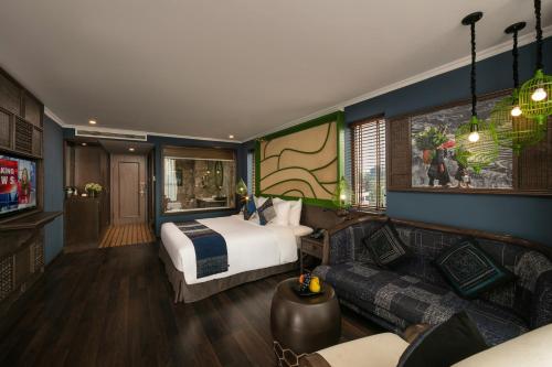 a hotel room with a bed and a couch at Pistachio Hotel Sapa in Sa Pa