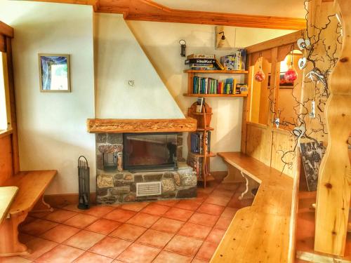 a living room with a stone fireplace in a house at Eco-Baita Natura Spensierata in Canale San Bovo