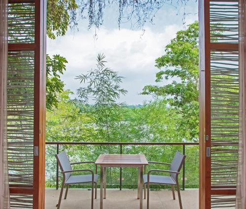 a table and chairs on a balcony with a view at Tri by Amaya in Ahangama