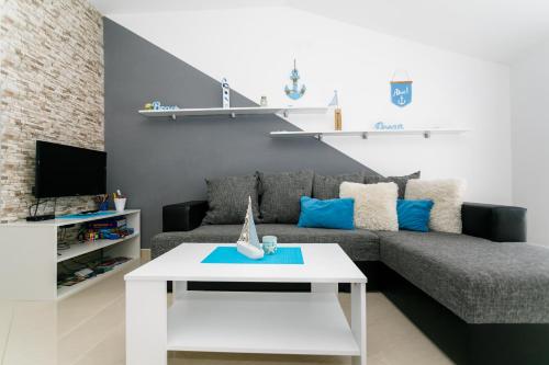 uma sala de estar com um sofá e uma mesa em Apartmani Brajutovci 26 em Kornic