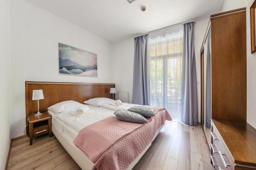 コウォブジェクにあるApartamenty Sun & Snow Bałtyk Park IIのベッドルーム1室(ベッド1台、大きな窓付)