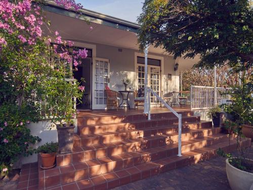 a set of stairs in front of a house with flowers at Corner House Residence in Franschhoek