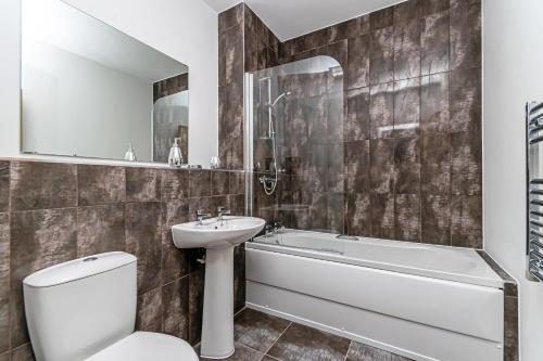 a bathroom with a toilet and a sink and a bath tub at City Suites by Guestz in Chester