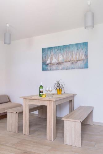 a wooden table and benches in a living room at Jovich Apartments 2 in Mošćenička Draga