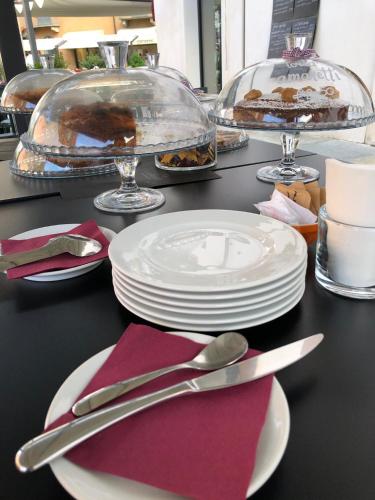 a table with plates and silverware on a table at Vinoteca La Sacrestia in Alba