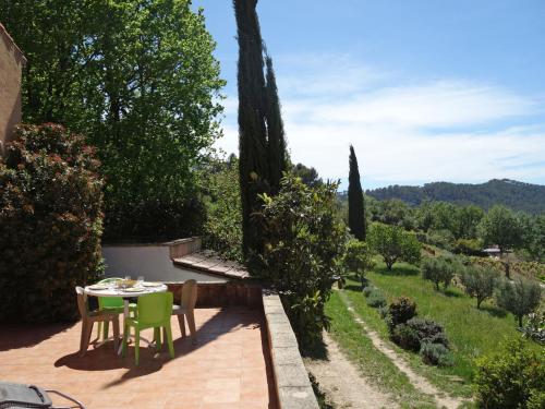 a table and chairs on a patio with a view at Holiday Home Les Vignes by Interhome in Saint-Côme