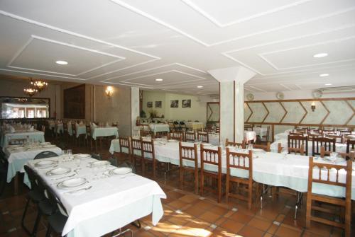 a dining room with white tables and chairs at Hosteria Peña Sagra in Ojedo
