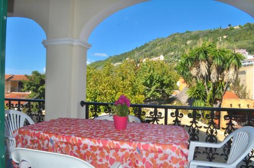 a table on a balcony with a view of a mountain at Holiday Apartments yannis on Agios Gordios beach in Corfu in Agios Gordios