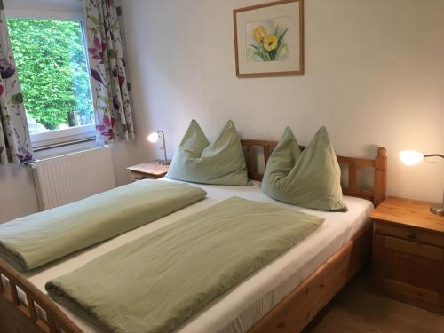 Un dormitorio con una cama con sábanas verdes y una ventana en Garten Apartment Diwoky en Sankt Gilgen