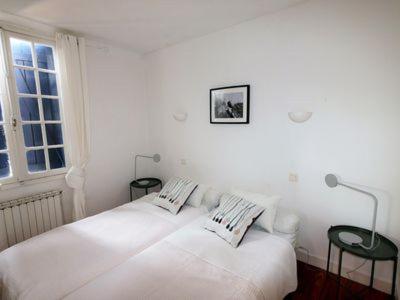 a white bedroom with two beds and a window at Charmant T2 bord de mer in Anglet