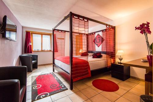 Un dormitorio con una cama con dosel en una habitación en Rêves Gourmands, Hôtellerie & Gastronomie, en Vernayaz