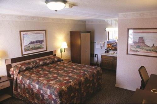 a hotel room with a bed and a bathroom at Wetherill Inn in Kayenta