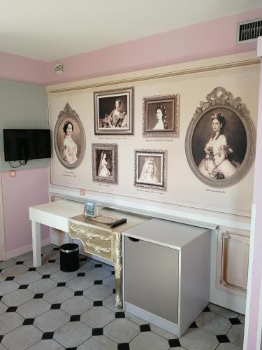 a room with a desk and pictures on the wall at Explorers Hotel Marne-la-Vallée in Magny-le-Hongre