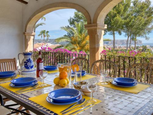una mesa con platos azules y servilletas en el patio en Holiday Home Adsubia by Interhome en Jávea