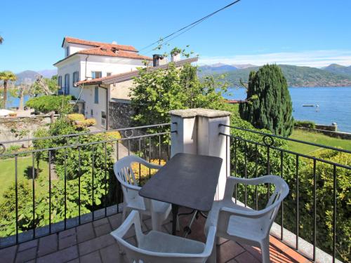 een tafel en stoelen op een balkon met uitzicht op het water bij Apartment La Silente by Interhome in Stresa