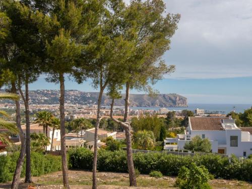 a view of a city with trees in the foreground at Holiday Home Adsubia by Interhome in Jávea