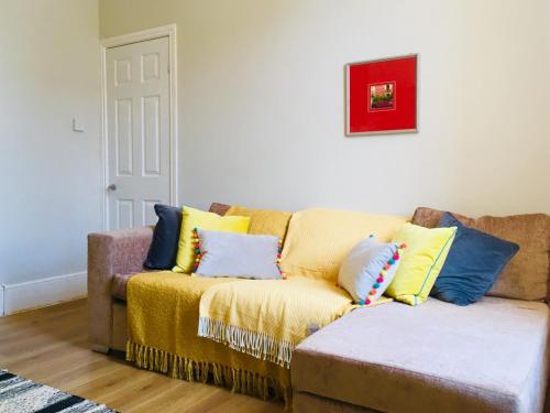 a couch with pillows on it in a living room at Bright Apartment in the Heart of St Leonards in Hastings