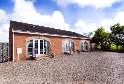a brick building with two windows and a fence at Skegness Holiday Cottages in Skegness