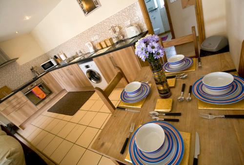 a kitchen with a table with plates and flowers on it at Skegness Holiday Cottages in Skegness
