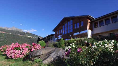 a building with a bunch of flowers in front of it at VVF La Plagne Montchavin Paradiski in Bellentre