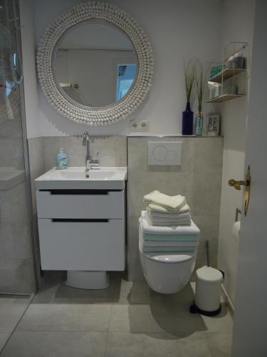 a bathroom with a sink and a toilet and a mirror at Strandperle 6 in Timmendorfer Strand