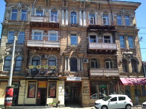 um edifício antigo com um carro estacionado em frente em Apartments Ilona em Odessa