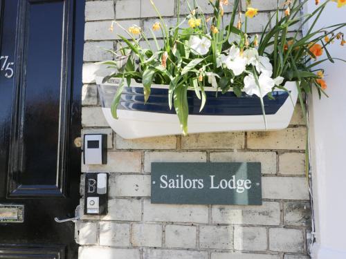 a pot of flowers on the side of a building at Sailors Lodge in Filey