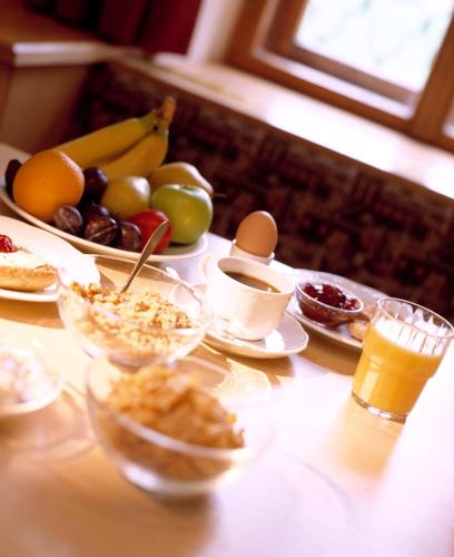 a table with a breakfast of fruit and eggs and coffee at Gästehaus am Graben in Reutte