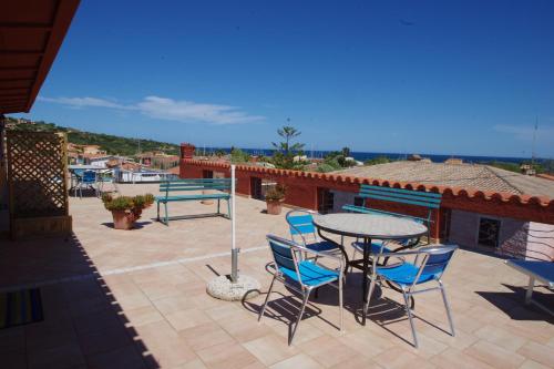 a patio with a table and chairs on a roof at Iocchedda in Porto Ottiolu