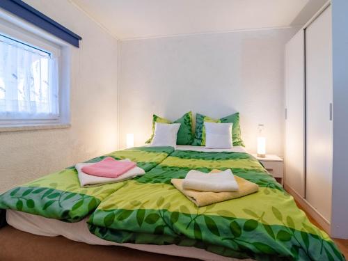 a bedroom with a large green bed with two pillows at Apartments Anamarija in Medulin