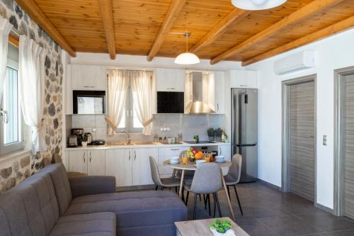 a kitchen and a living room with a couch and a table at Marilena Natural Stone House, By Hellocrete in Pigi