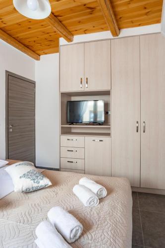 a bedroom with a bed with white towels on it at Marilena Natural Stone House, By Hellocrete in Pigi