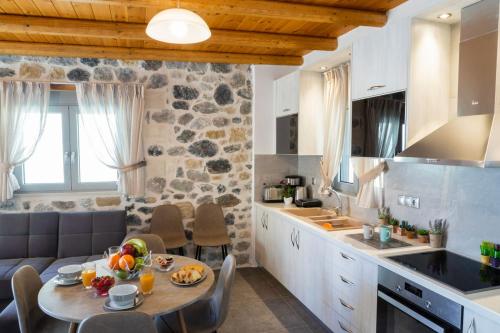 a kitchen and dining room with a table in a kitchen at Marilena Natural Stone House, By Hellocrete in Pigi