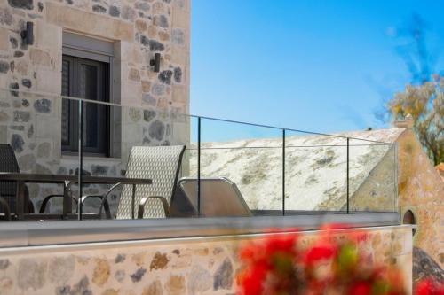 a balcony of a house with a table and chairs at Marilena Natural Stone House, By Hellocrete in Pigi
