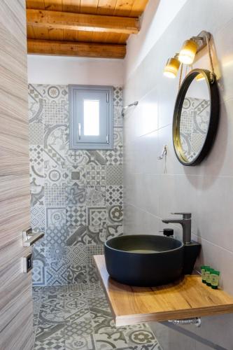 a bathroom with a black sink and a mirror at Marilena Natural Stone House, By Hellocrete in Pigi