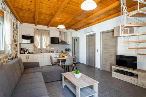 a living room with a couch and a table at Marilena Natural Stone House, By Hellocrete in Pigi